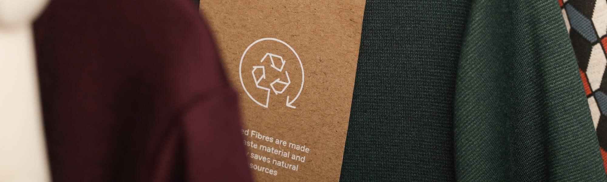 L'immagine mostra il cartellino di un vestito fatto di materiali riciclati, come buona pratica per una moda sostenibile.
